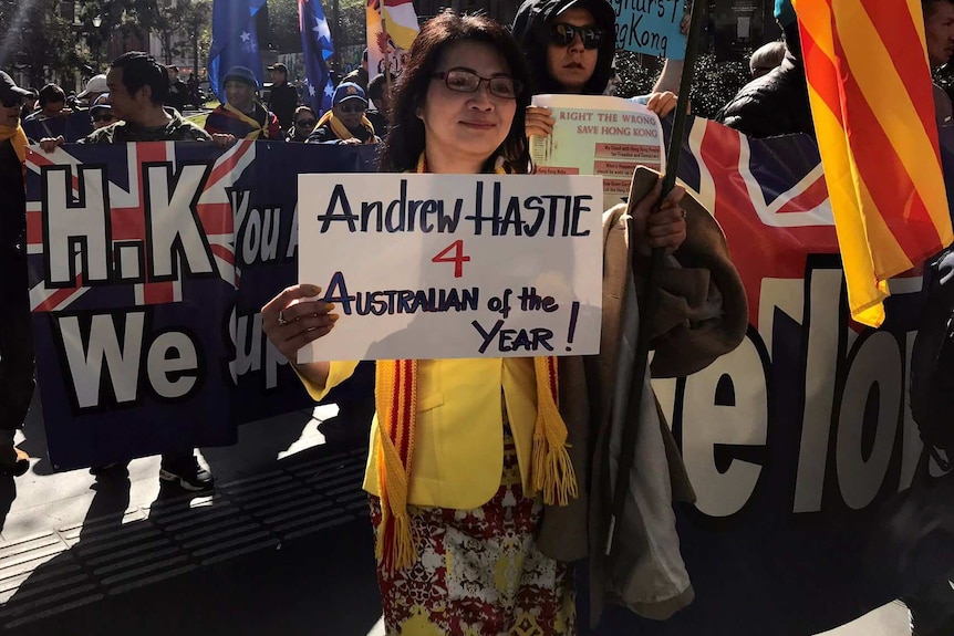 A woman at an anti-China rally in Melbourne holds up a sign in support of Liberal MP Andrew Hastie