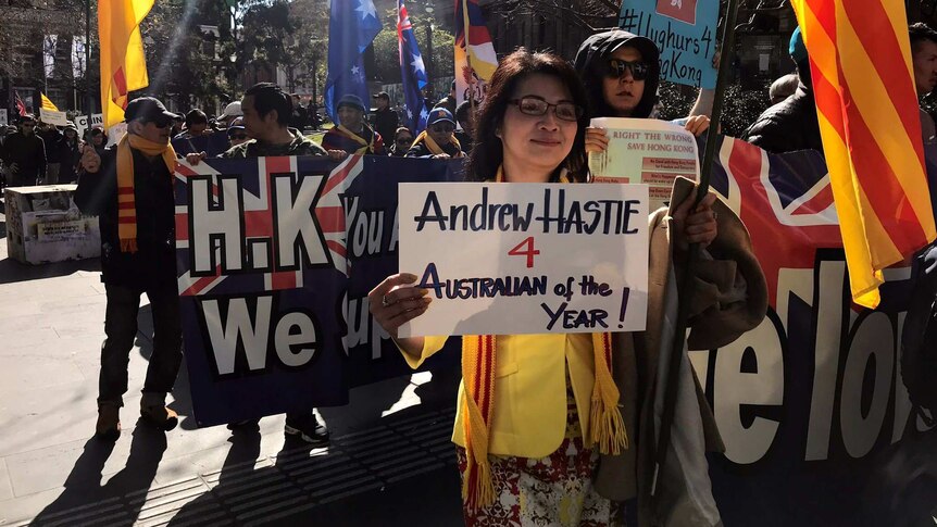 A woman at an anti-China rally in Melbourne holds up a sign in support of Liberal MP Andrew Hastie