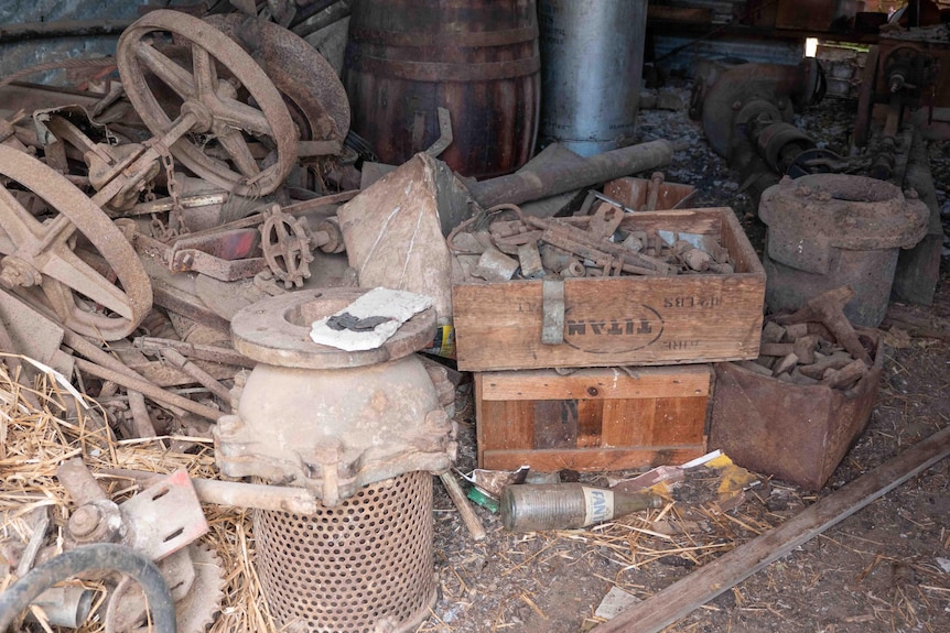 Old rusty farm items including a box of bolts and cart wheels