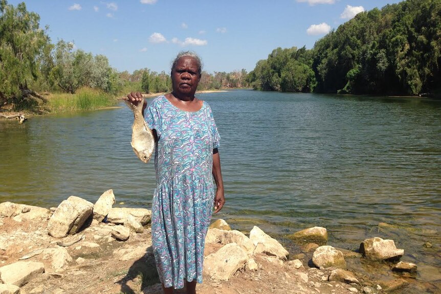 Garawa traditional owner Nancy McDinny stands at the McArthur River with a fish.
