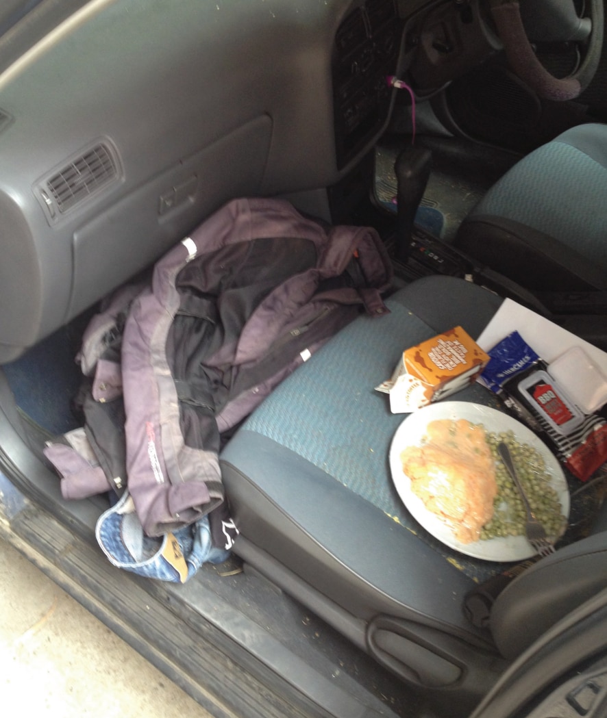 The interior of a car showing a plate of food on the passenger seat