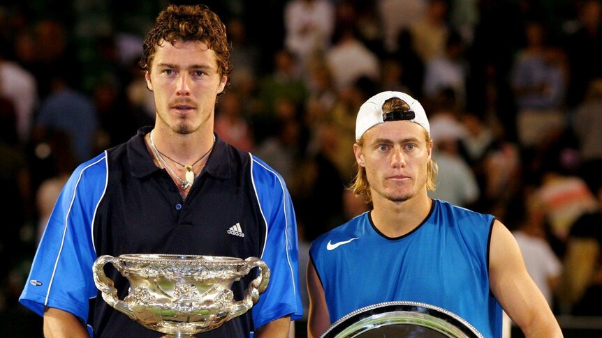 Marat Safin (L) and Lleyton Hewitt stand with their trophies after the 2005 Australian Open final.