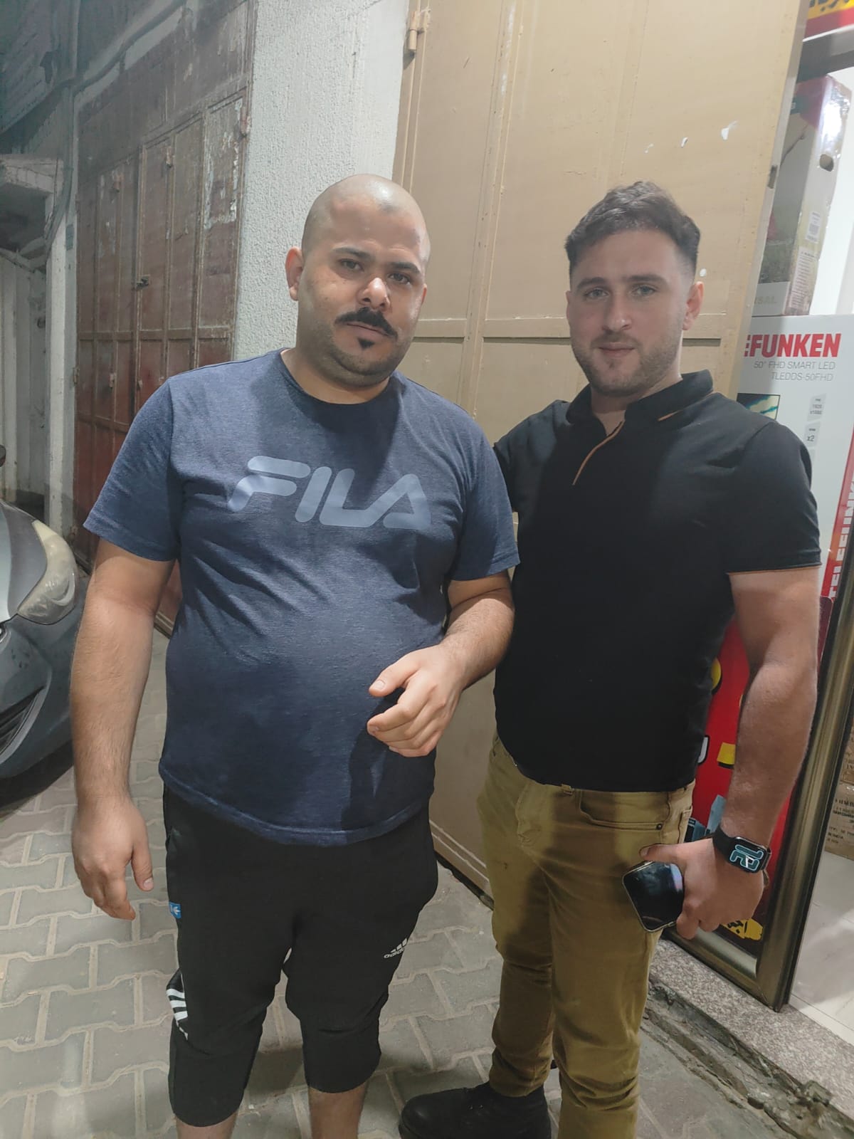 Mahmoud Almadhoun and another man stand next to one another.