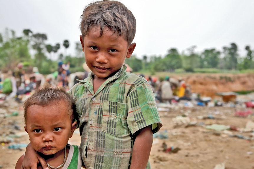 Young boys embrace at a Cambodian rubbish dump