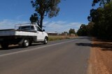 A utility vehicle drives along a narrow single-lane road in WA's South West