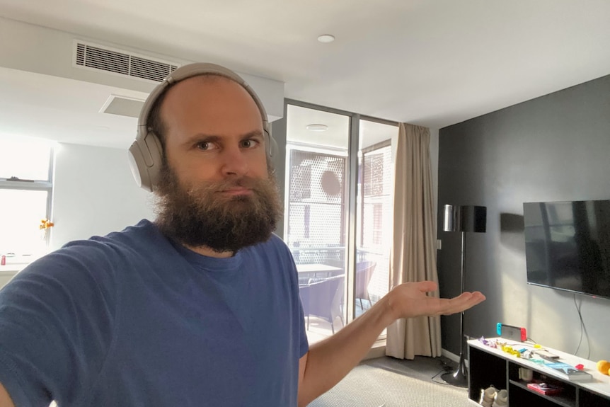 A man stands in a hotel room.