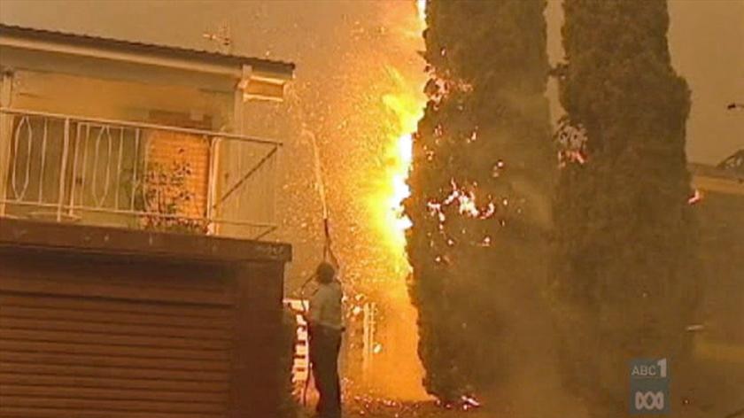 A man housing down his house during the 2003 Canberra bushfires.