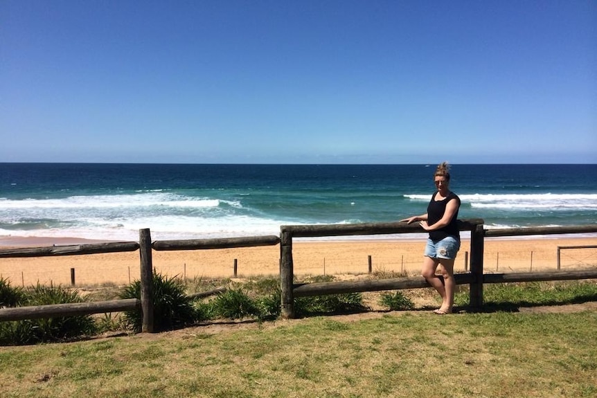 Aleisha Hausler leans up against a railing at a beach in Warrnamool