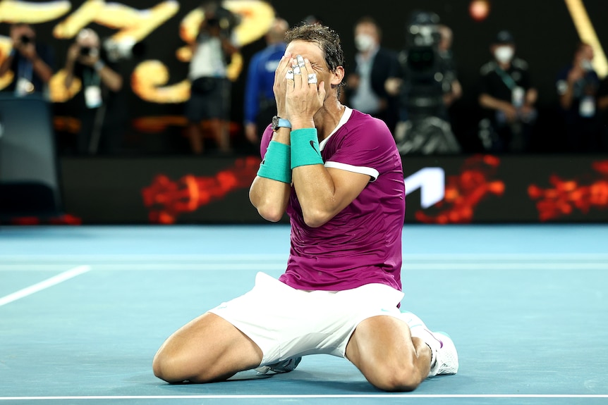 Rafael Nadal puts his hands to his face while on his knees after winning the Australian Open.