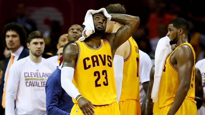 Tough night at the office ... LeBron James holds a towel on his head after falling into a photographer