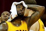 Tough night at the office ... LeBron James holds a towel on his head after falling into a photographer