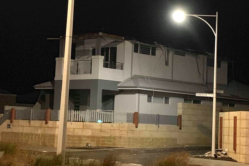 A two-storey house without its roof at night.