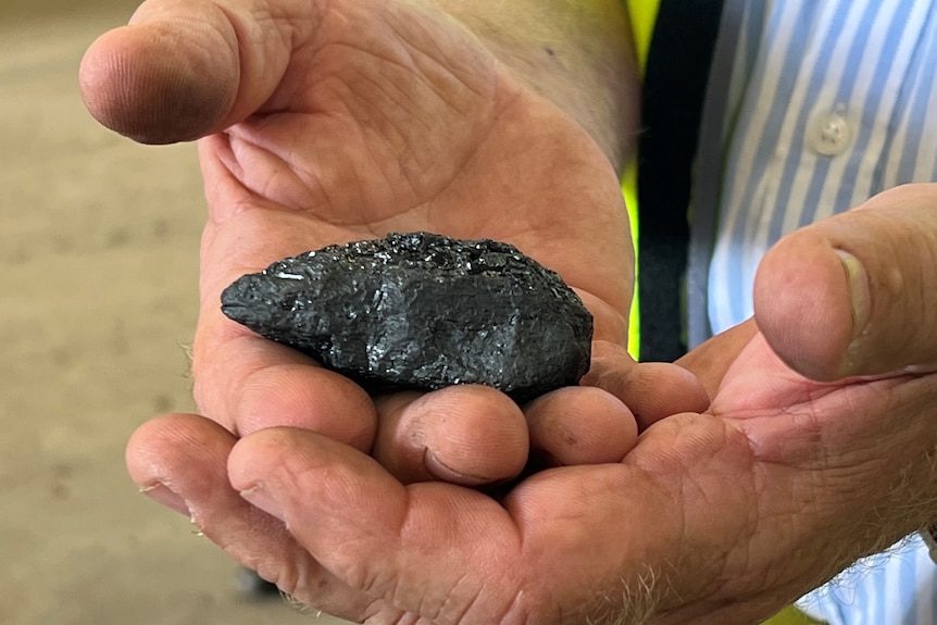 Снимка в близък план на буца въглища, която се държи