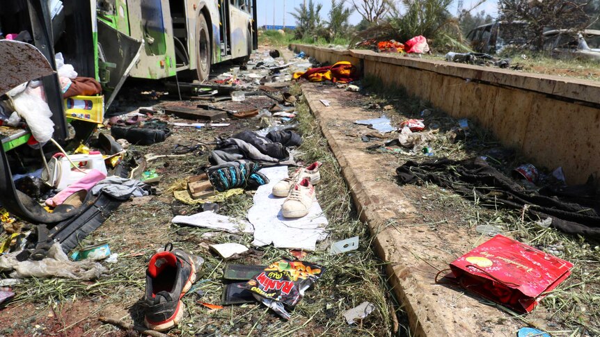 Scattered shoes lie on the ground near the damaged buses after the explosion.