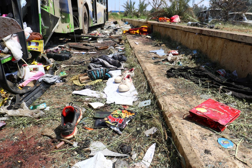 Scattered shoes lie on the ground near the damaged buses after the explosion.