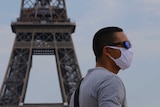 A man wearing a mask to prevent the spread of COVID-19 walks at Trocadero plaza near Eiffel Tower in Paris.