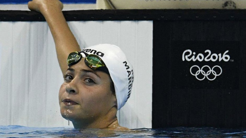 Yusra Mardini holds onto the end of the pool in Rio after her race. Photo AFP