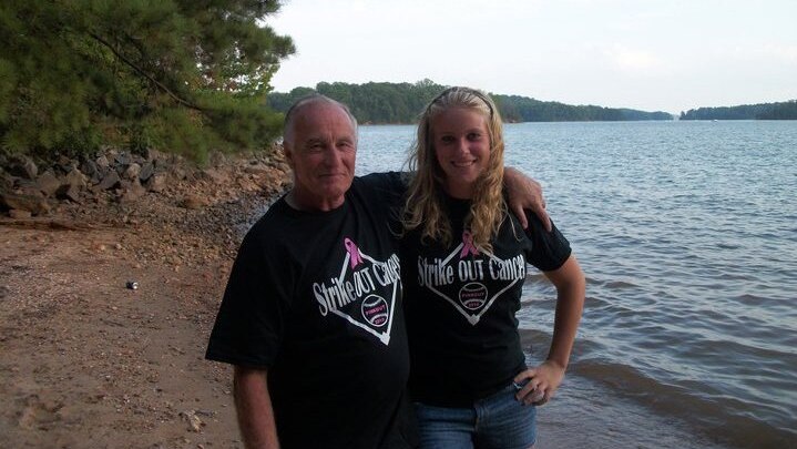 Douglas Parkhurst poses with his granddaughter by a lake.