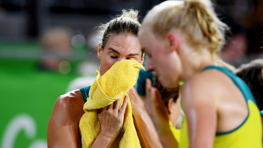 Caitlin Bassett wipes her eyes with a cloth.