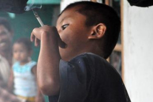 An Indonesian child holding a cigarette.