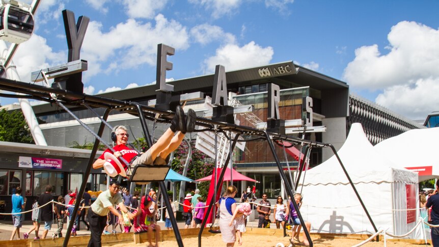 A Brisbane visitor tries out the infinity swing which generates electricity through movement.