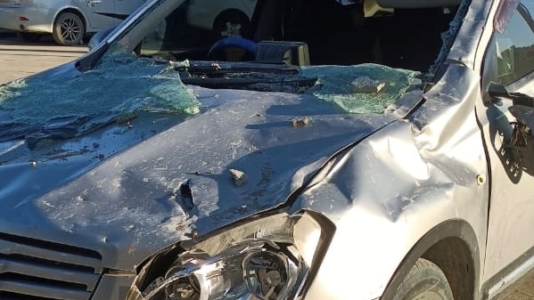 a car with its windscreen broken and bonnet bust up from fallen masonry