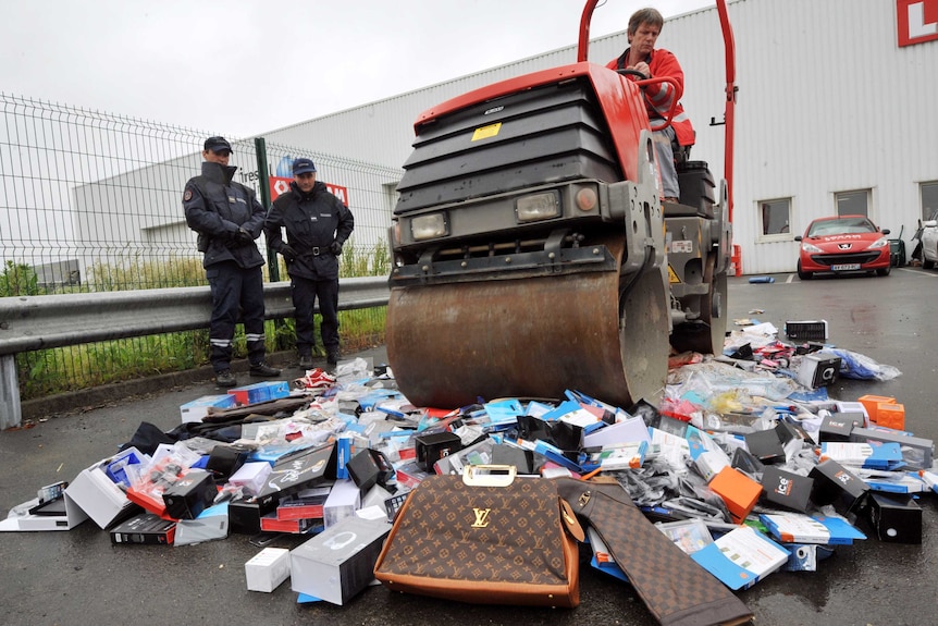 French customs agents look on as counterfeit items are destroyed in Vertou, western France.