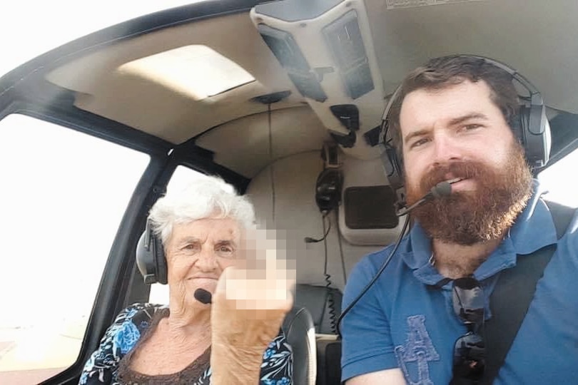 An older woman in a helicopter next to a younger man
