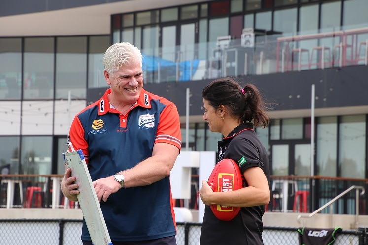 Gary Ayres points to a clipboard and stares at Peta Searle.