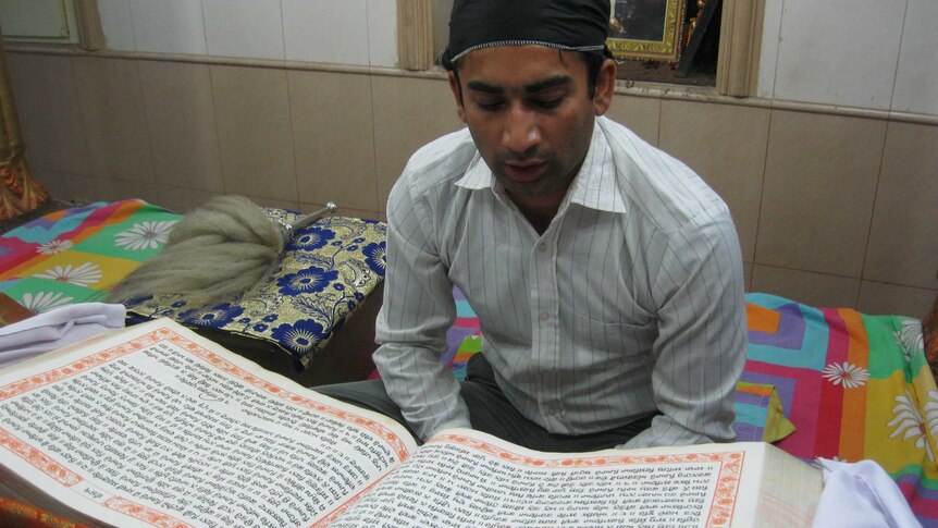 A young Hindu recites from a holy book in a local temple.