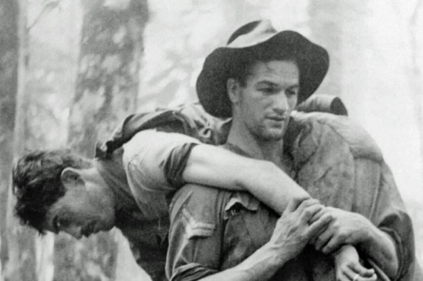 Black and white photo of Leslie 'Bull' Allen carrying wounded soldier