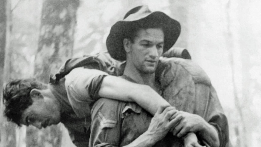 Black and white photo of Leslie 'Bull' Allen carrying wounded soldier