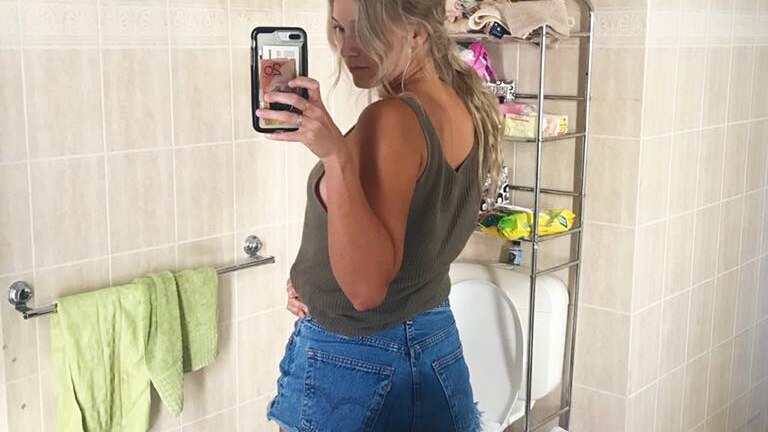 Emma Carey stands in front of a mirror, her shorts soaked in urine.