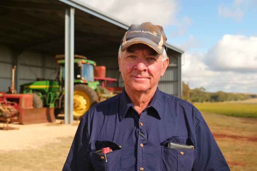 A farmer is holding unprocessed peanuts in his hands.