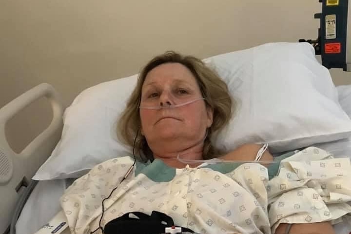 A woman lying in a hospital bed with a oxygen tube