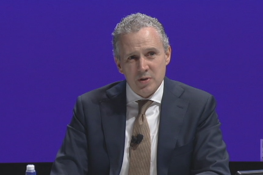 Telstra CEO Andy Penn in front of a blue background