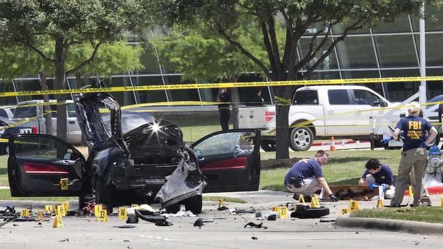 Local police and FBI investigators collect evidence where two gunmen were shot dead in Texas