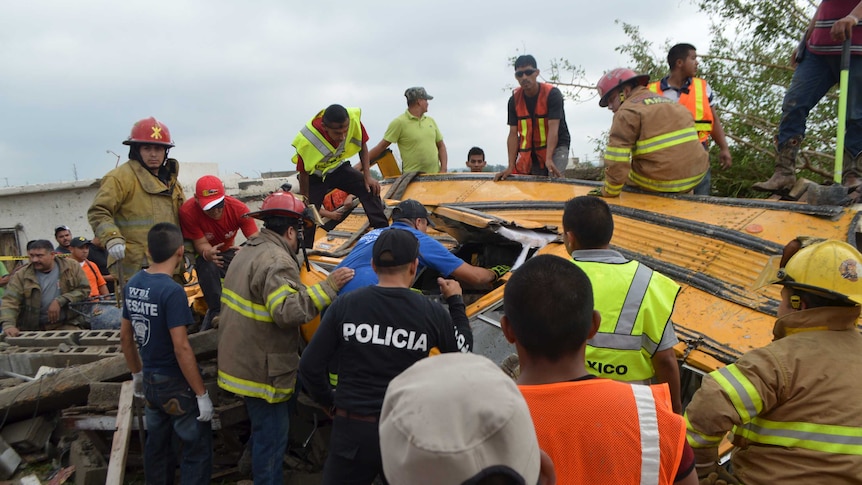 Firefighters inspect a tornado damaged bus