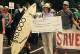 Protestors with a cheque for $90,000.