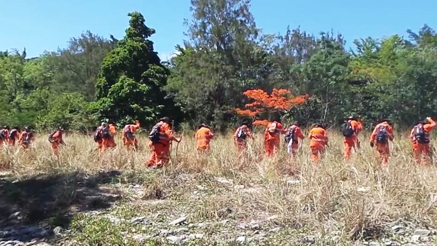 SES volunteers do a line search of an area near Lake Placid.