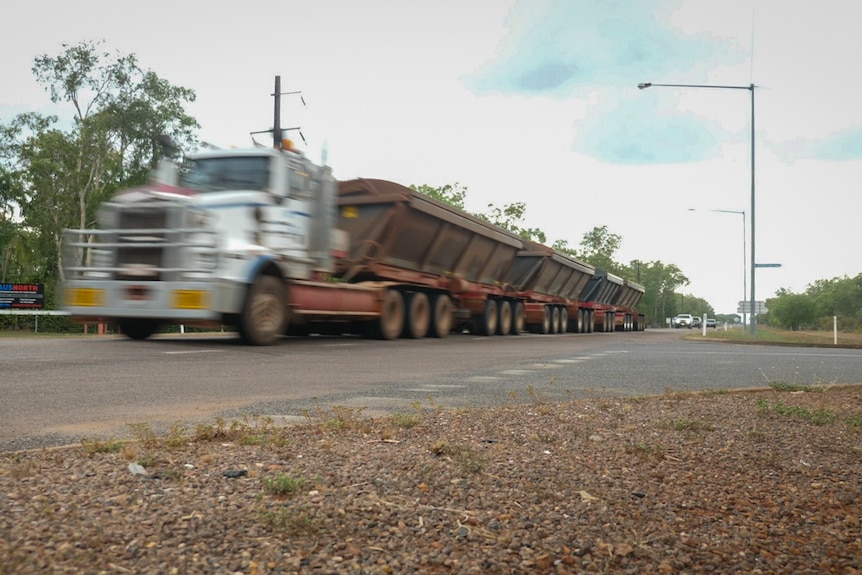 A truck with trailers rushes by.