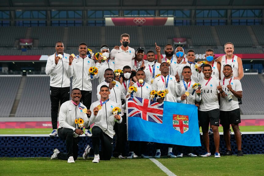 Fiji 7's players celebrate on the podium with their gold medals