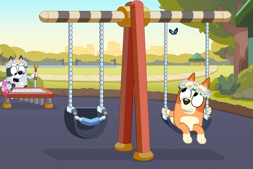 A still from Bluey with Bingo on a swing looking at a blue butterfly above her.