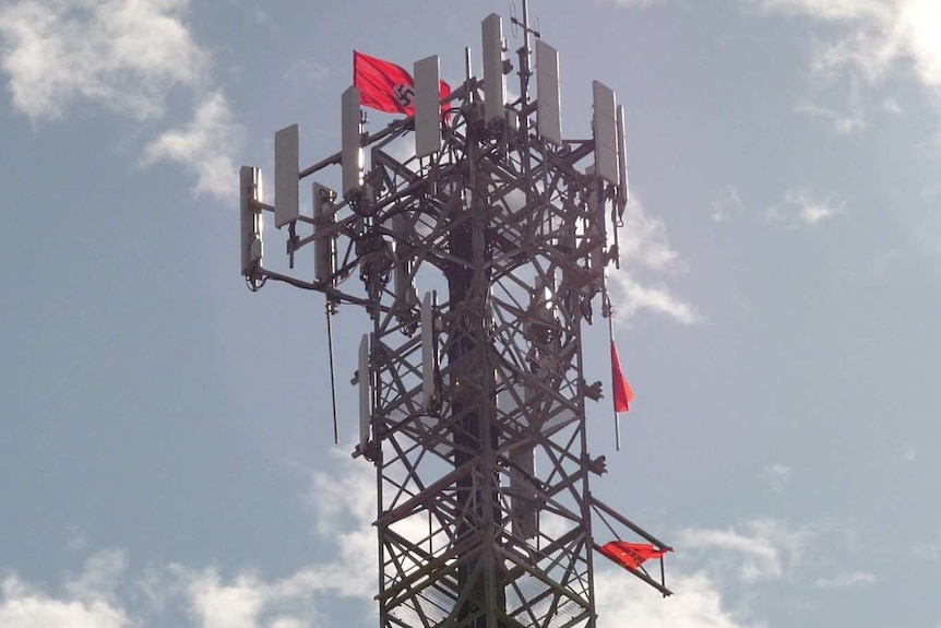 A Nazi and two China flags up high on a telecoms tower.