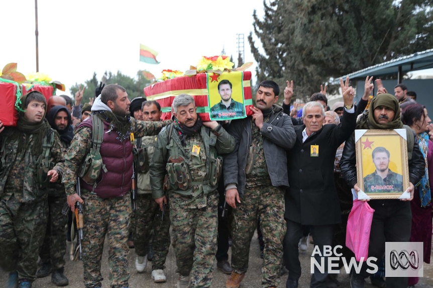 Kurdish fighters carry the coffin of Ashley Johnston