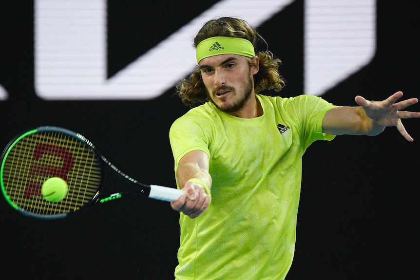 Stefanos Tsitsipas playes a forehand return against Daniil Medvedev.