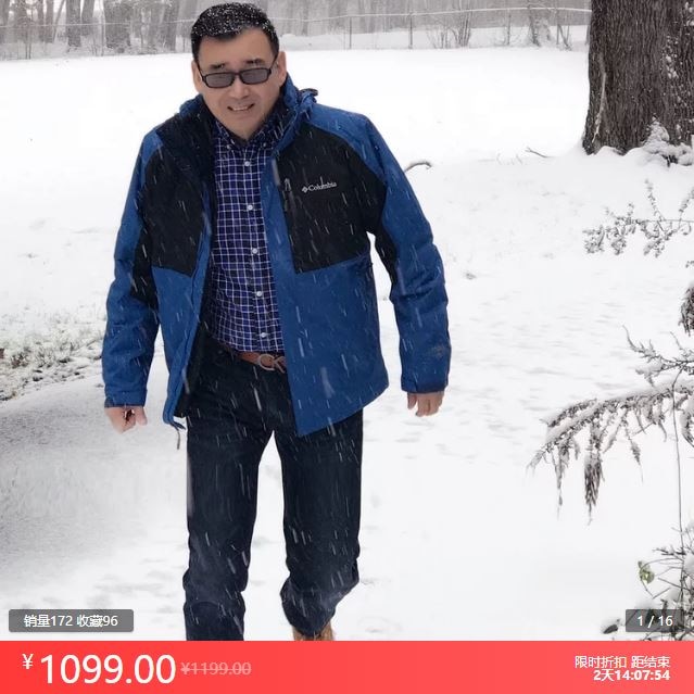 A mid-age Chinese man wearing a down jacket standing outdoor while it was snowing.