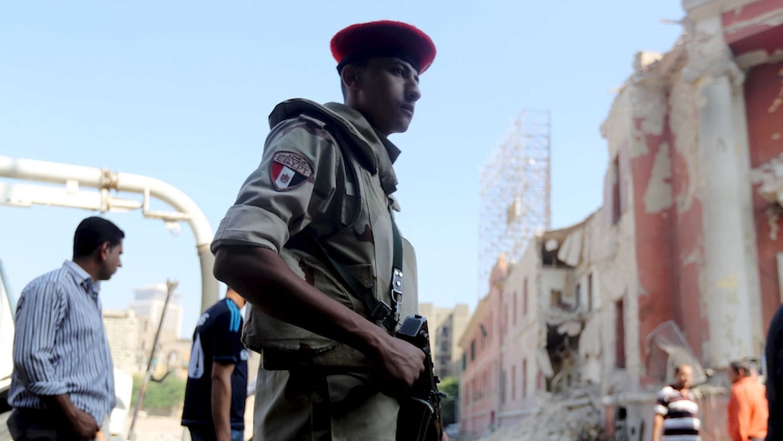 Egyptian security officials inspect the site of a bomb blast at the Italian Consulate