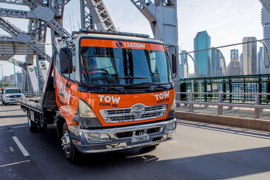 Tow truck of tow.com.au driving on a road.