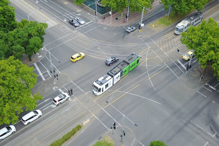 A car and a tram in an intersection in South Melbourne.